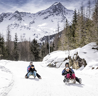 Familie beim Rodeln in Sölden
